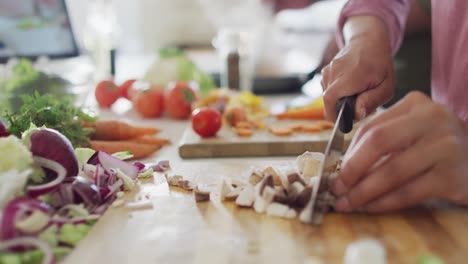 Close-up-of-african-american-couple-cooking-in-kitchen