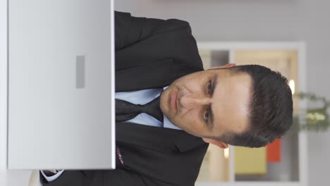 Vertical-video-of-Home-office-worker-man-working-seriously-and-focused.