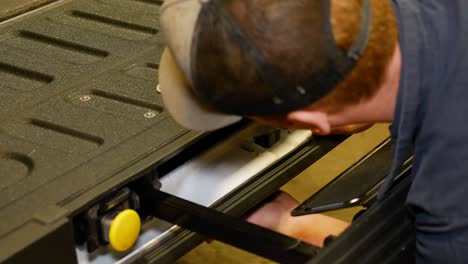 a mechanic uses a electric driver to remove the tailgate handle on a truck