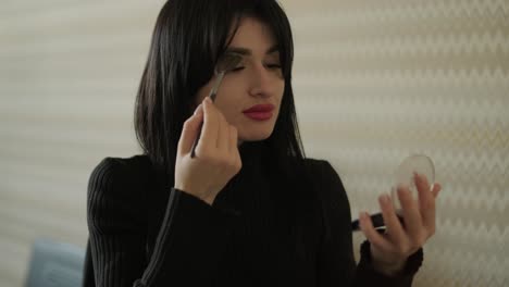 mujer de negocios profesional en su oficina aplicando maquillaje, vestida con elegantes trajes de negocios, equilibrando el cuidado personal y las responsabilidades laborales en un entorno de oficina moderno