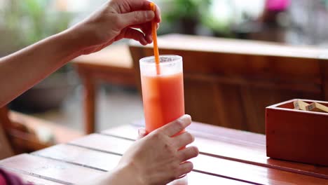 person mixing a drink with a straw