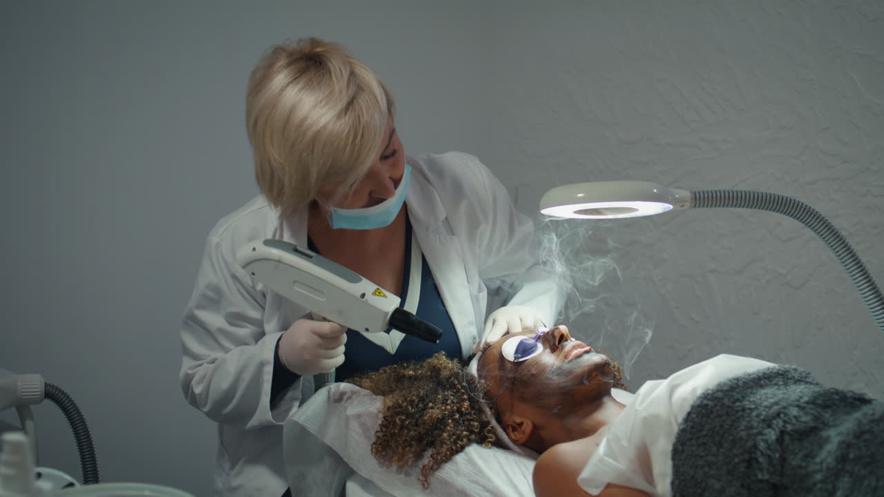 cosmetólogo haciendo un procedimiento de peeling en un salón de belleza. médico examina la piel de la cara