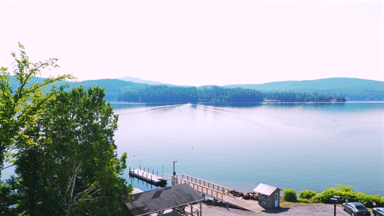 Byen Lake Schroon, WOL sø, bygninger, færge, bådbroer, kyst, luftfoto fra drone, Upstate New York, sommermorgen, solrig blå himmel, Adirondack-bjergene, Lake Schroon landskab, havneudsigt opad.