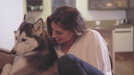 hermosa mujer joven relajándose en su sala de estar con su adorable perro