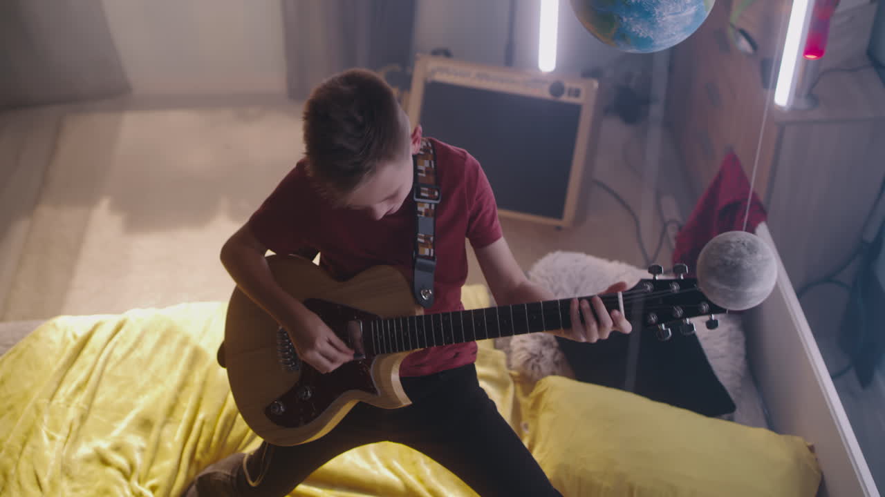 Teenager Playing Electric Guitar in Bedroom
