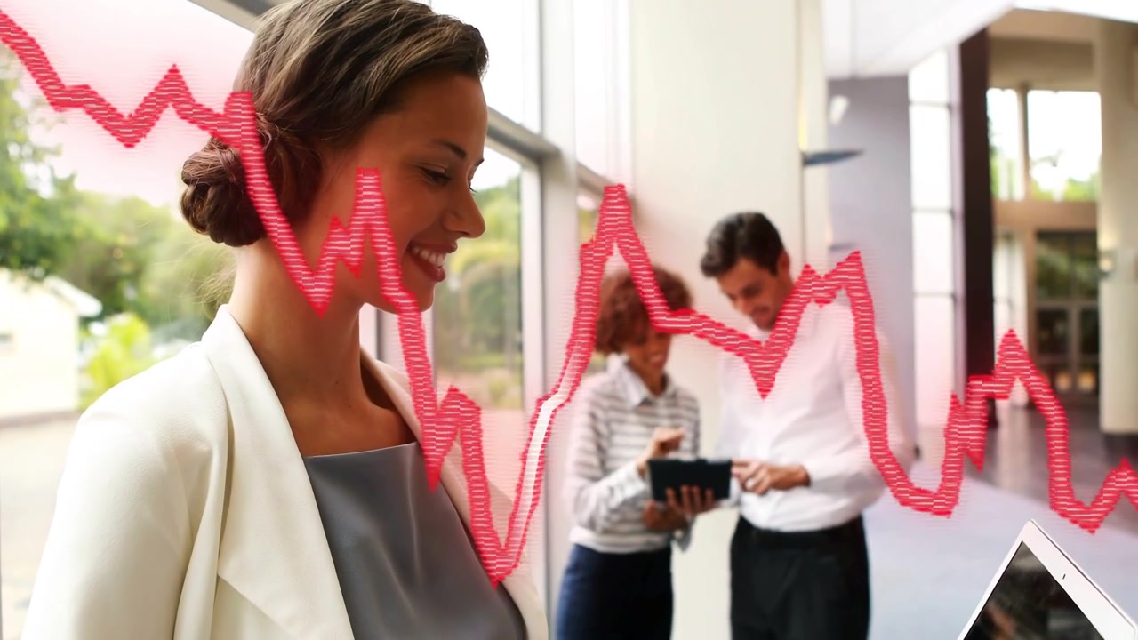 Camera panning showing office woman holding laptop, typing and sharing while red waveform scrolling