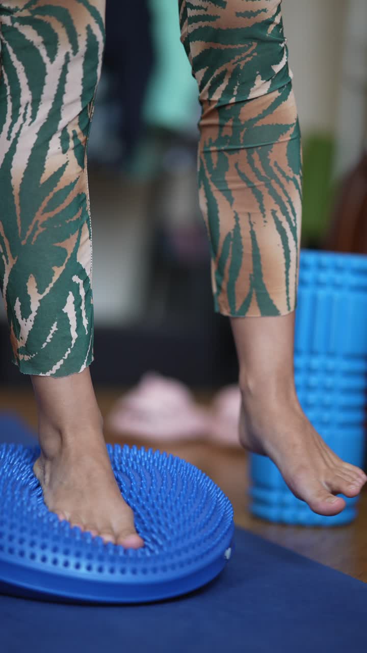 mujer practicando ejercicios de equilibrio en una tabla de equilibrio