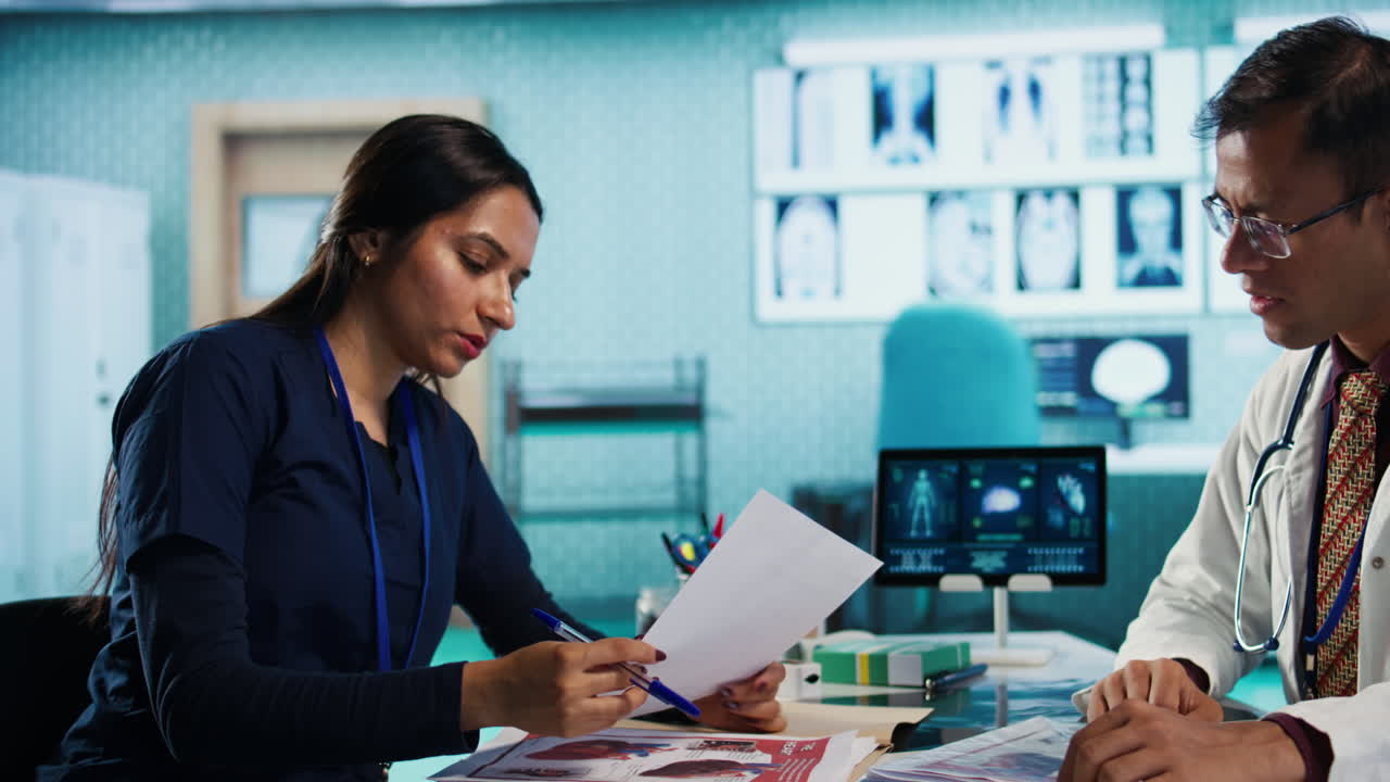 Doctors reviewing medical records and patient x-rays in medical office