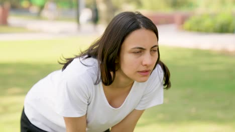 Mujer-Descansando-Entre-Entrenamiento-En-Un-Parque-Por-La-Mañana