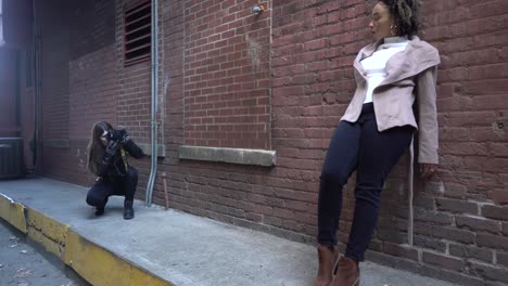 black model poses for a photographer in an alleyway.