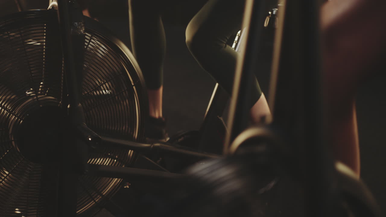 Woman Exercising on an Air Bike in a Gym