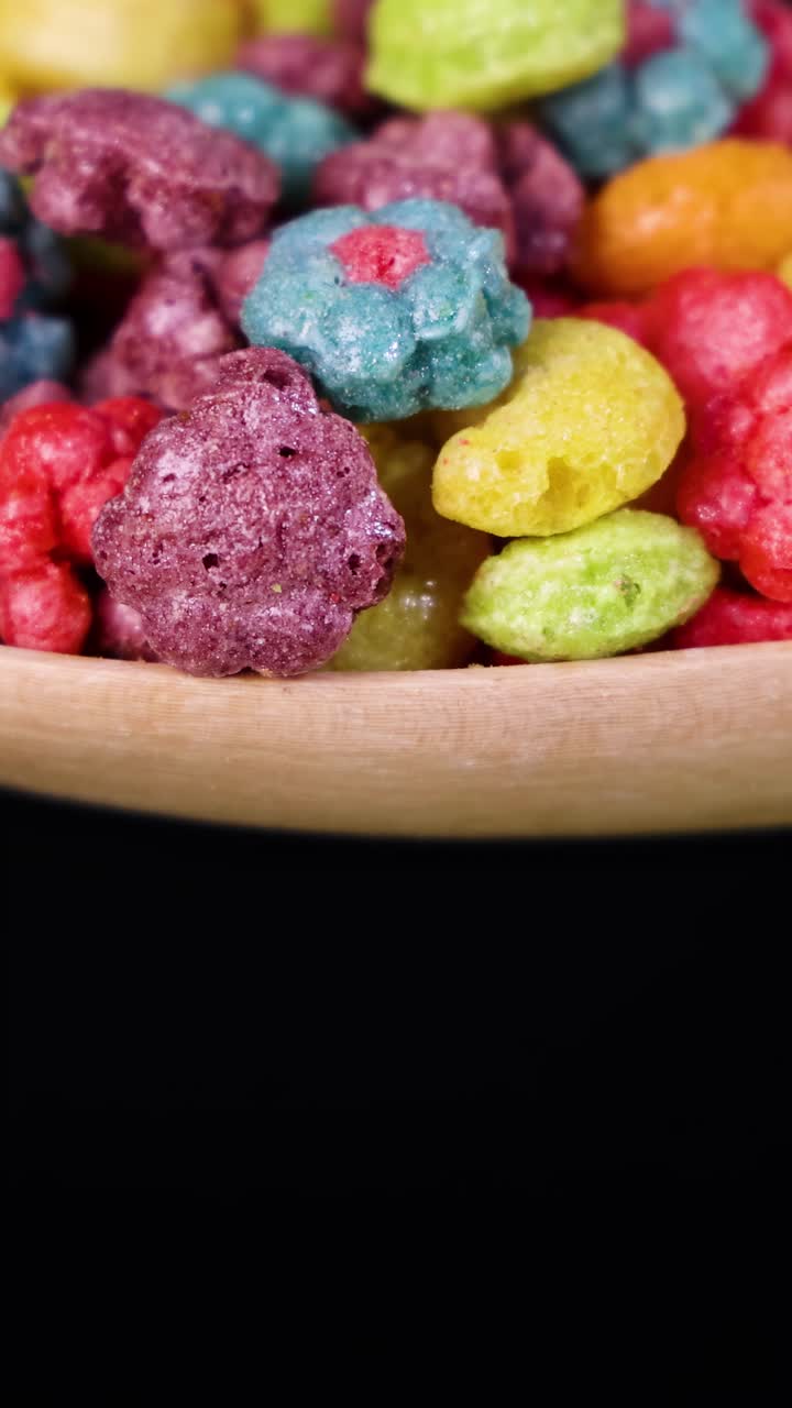 Pedaços de Cereal Vibrantes Caindo de uma Colher Contra um Fundo Preto, Capturados em Câmera Lenta para um Efeito Visual Dinâmico