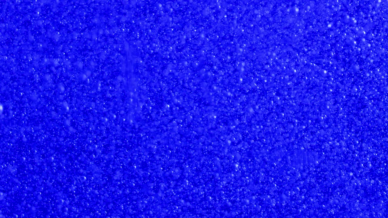 미세한 거품이 밝은 파란색 배경을 통해 상승합니다.