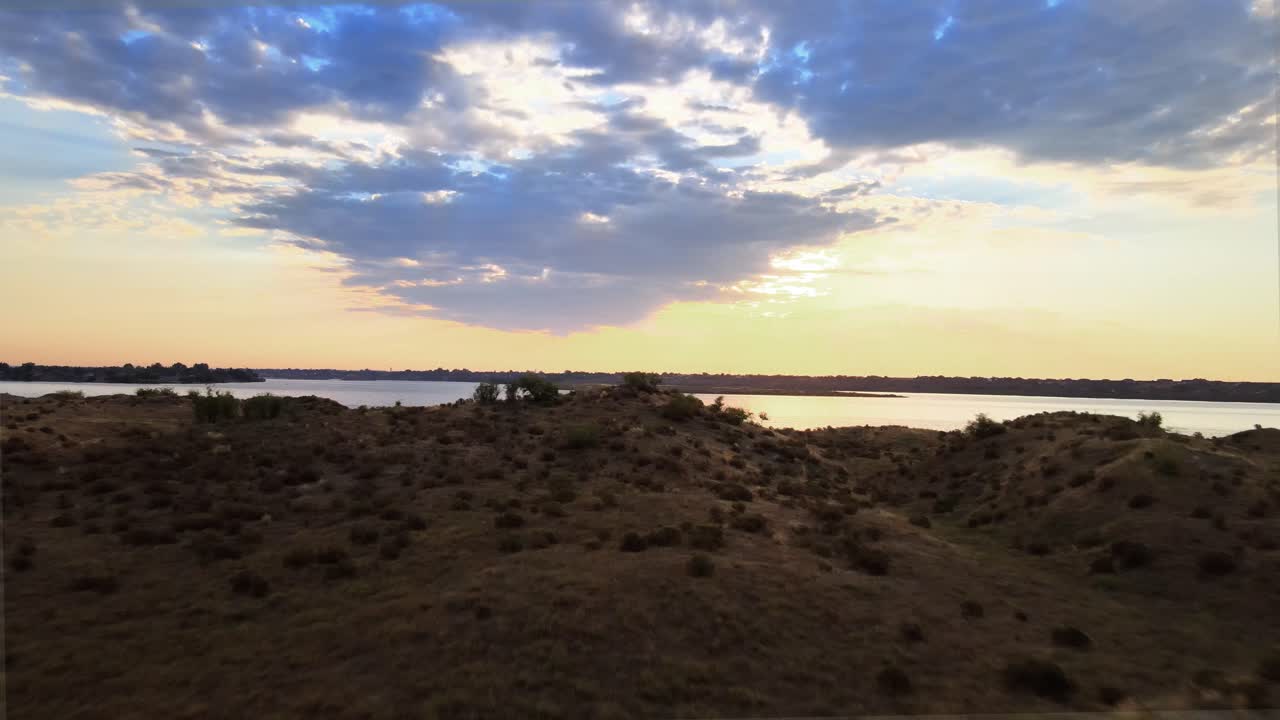 elevándose sobre matorrales revelando un lago prístino que refleja el amanecer dorado, antena