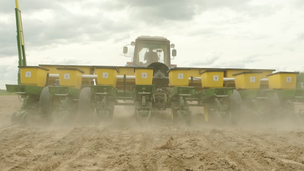 특별한 정밀 플랜터를 가진 트랙터, 시더가 에서 일하고, 농업 기계가 옥수수 또는 꽃 씨을 새로 은 땅에 심고 있습니다.