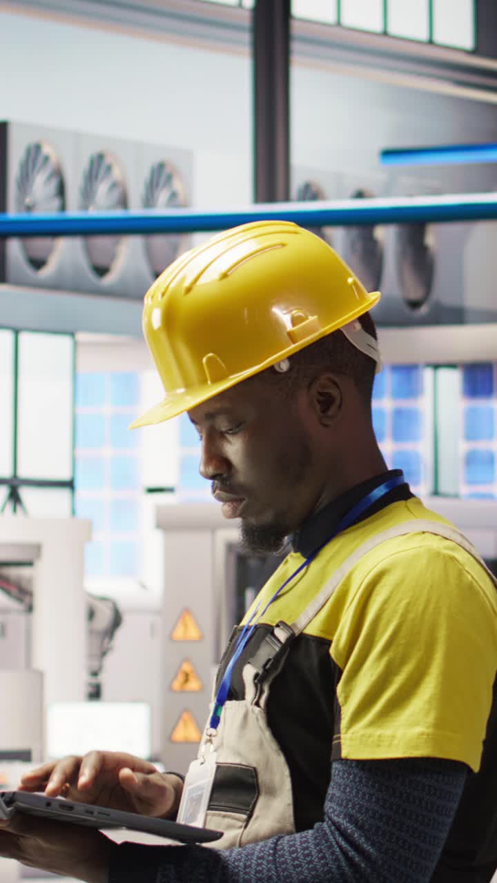Vertical video Technician in smart factory using notebook to look at system performance metrics