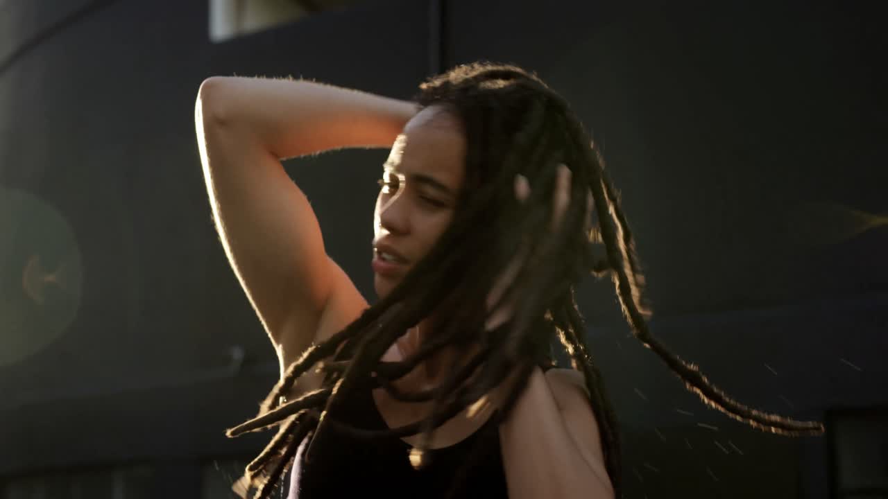 vista frontal de una joven afroamericana sacudiendo la cabeza en la ciudad 4k