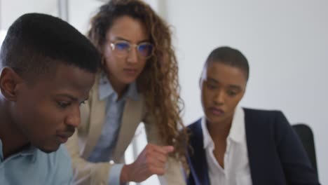 biracial female and male architects talking and checking architects plans in modern office