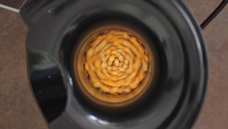 Pop-corn-kernel-spinning-in-electric-machine,-top-close-up-shot