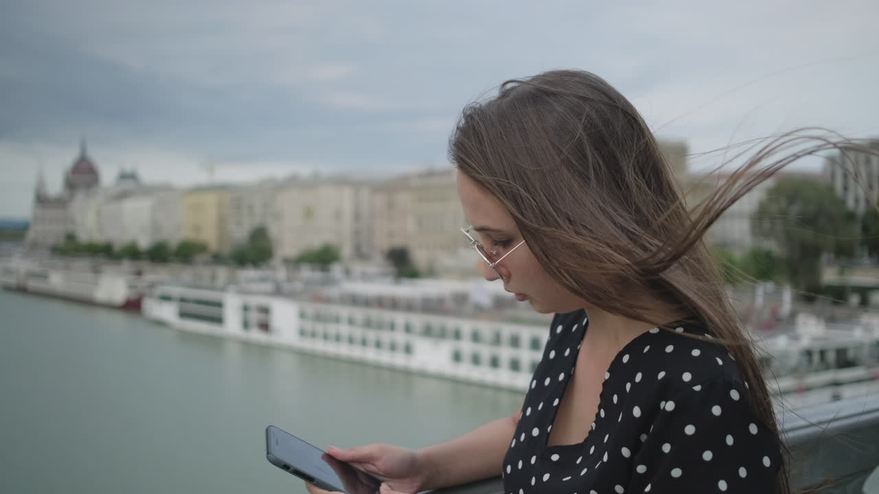 joven usando un teléfono inteligente en un puente