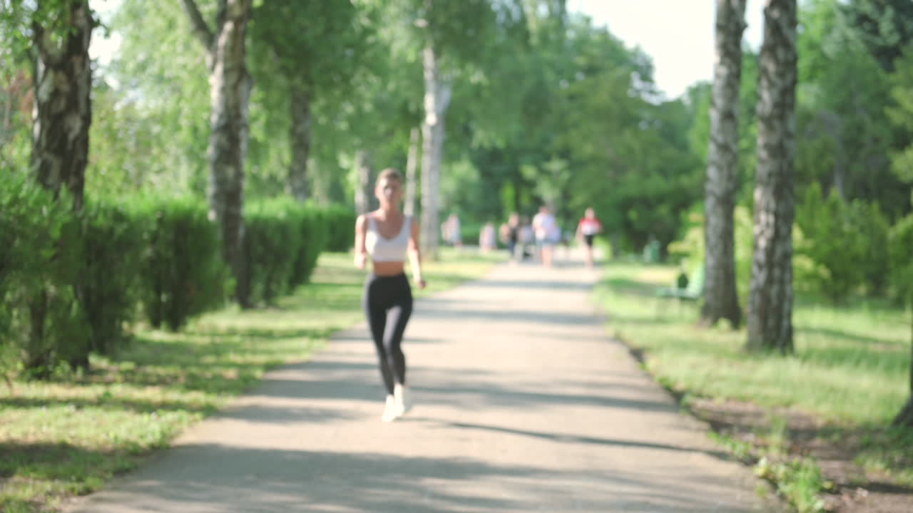 красивая блондинка бежит по парку в солнечный день