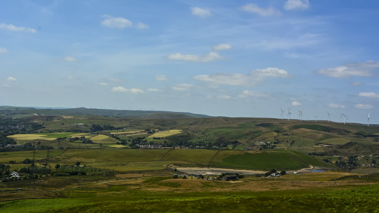 gran toma ancha con nubes y sombras de nubes, con molinos de viento y líneas eléctricas