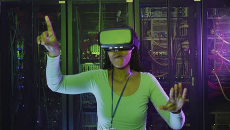 técnica informática afroamericana que usa auriculares vr trabajando en la sala de servidores de negocios