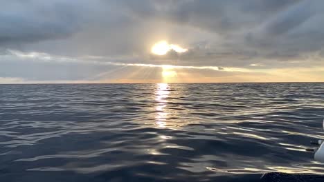 dreamy, relaxing, calming, peaceful, ocean sunset. dramatic clouds with sun rays glistening over the calm seas. slow motion video