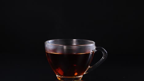 a sugar cube drops into a tea cup, creating a splash against a black background. captured in high-speed photography