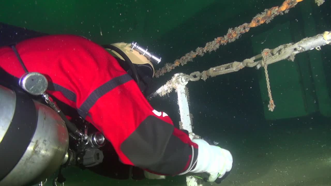 Sidemount tech diver makes initial tie-off of the line