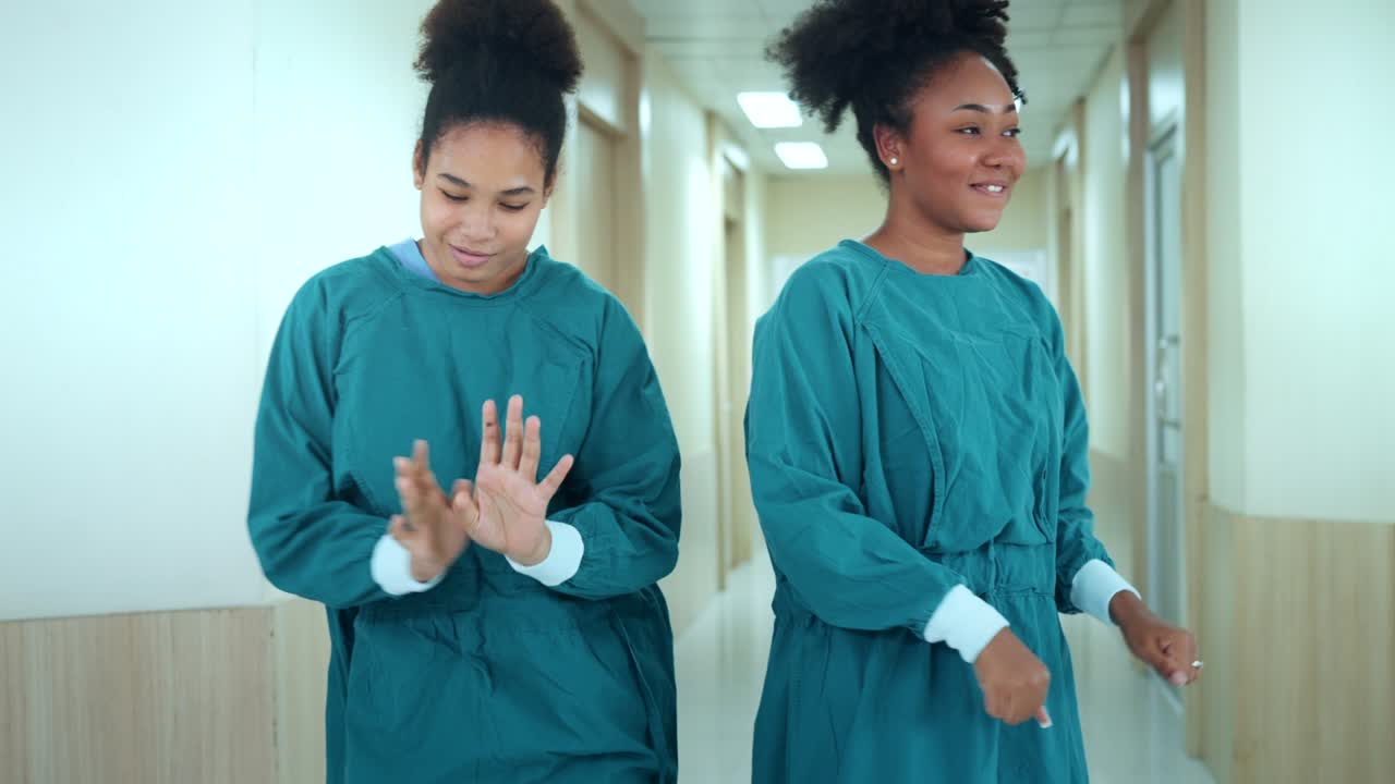 Happy African American nurses and assistants dances while walk through the corridors of hospital. medical personnel having enjoy.