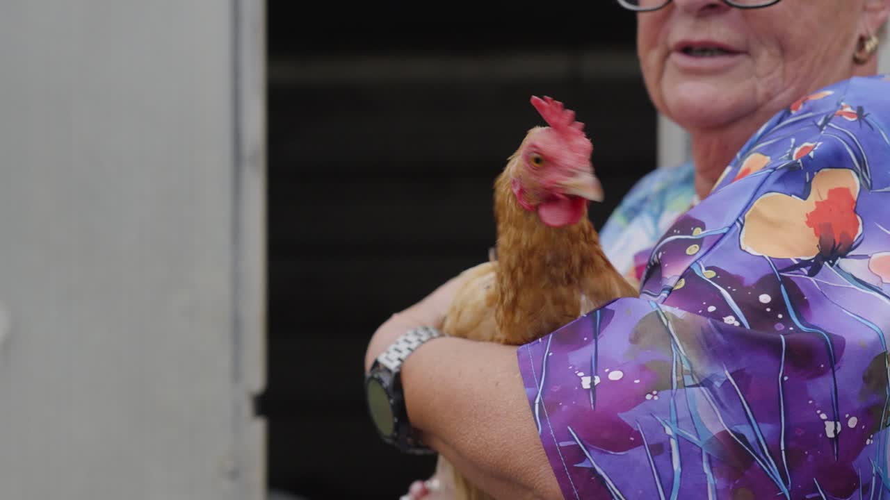 Elderly Woman Holding a Chicken