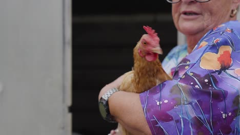 elderly woman holding a chicken