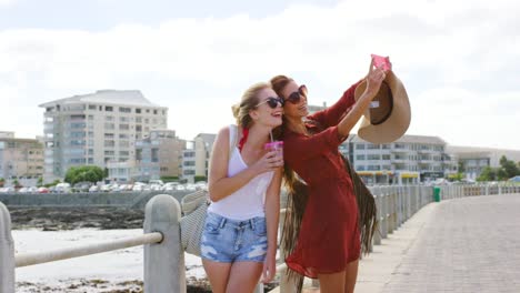 4k video footage of two friends taking selfies on the promenade