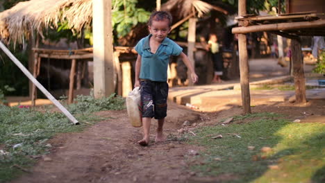 a boy carrying water in a rural village