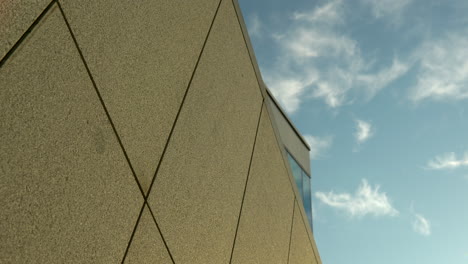 Modern building corner against a backdrop of wispy clouds