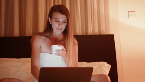 mujer trabajando en la computadora portátil en la cama por la noche