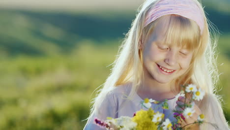 cool blonde child looks at a bouquet of wildflowers in my hands