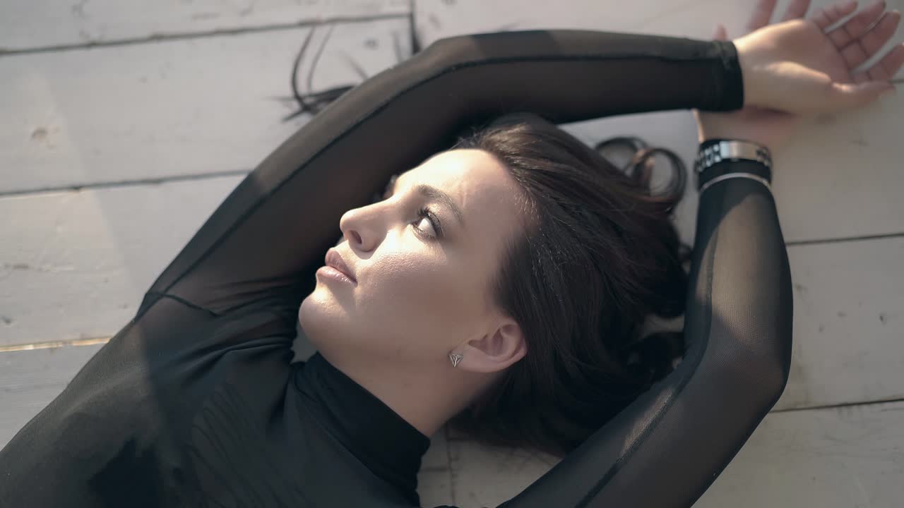 foto de cerca de una chica de cabello largo posando en el piso de madera vista superior