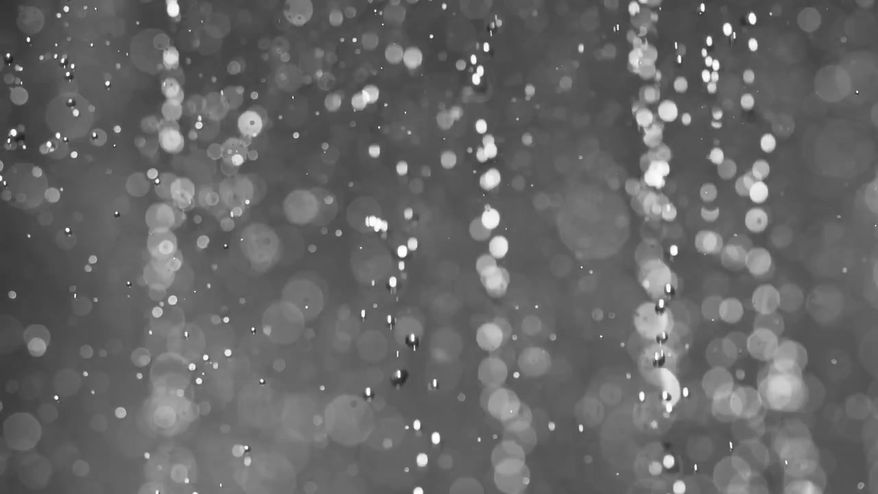 Particelle astratte bokeh fluttuanti su sfondo scuro. Ripreso con una fotocamera super slow motion a 1000 fps