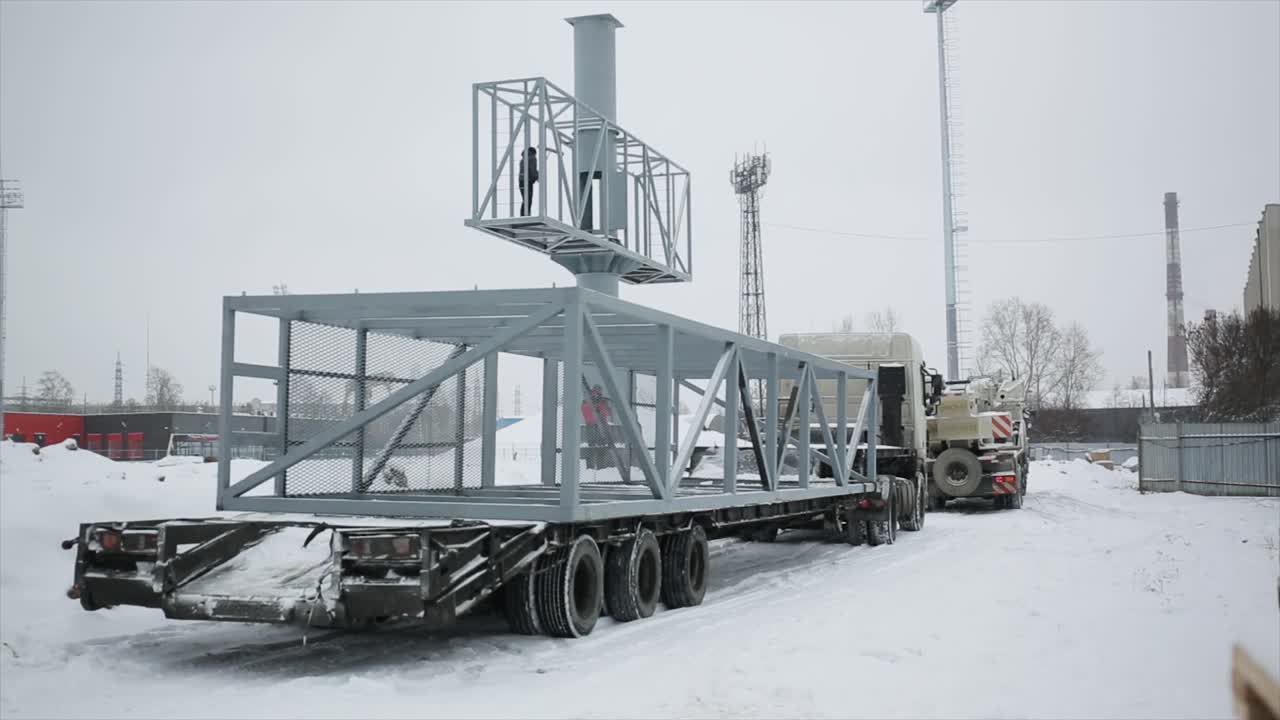 겨울에 큰 금속 구조물을 운반하는 트럭