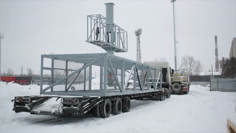 truck transporting large metal structure in winter