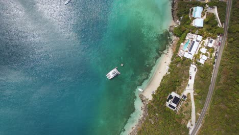 Aerial-view-above-a-yacht-and-holiday-homes-on-the-coast-of-Saint-Thomas,-USA---overhead,-drone-shot