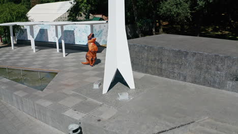 person in a dinosaur costume in a park