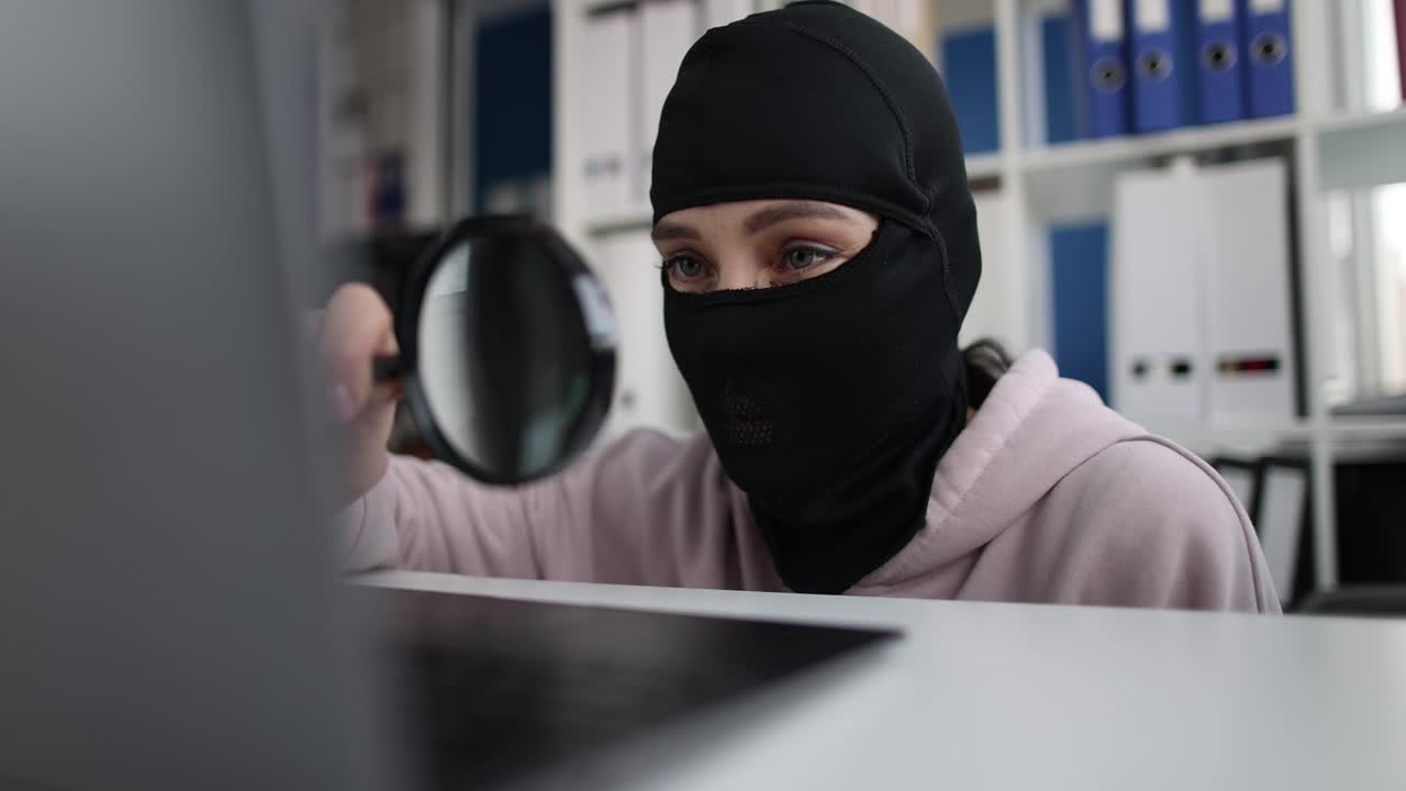 Hacker Using Magnifying Glass on Computer