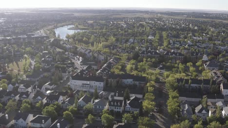 aerial fly over inverness elgin hills south east calgary alberta during sunrise on a hot summer morning in canada where the residential community resembles brick homes of scotland in the uk britain