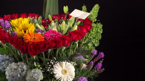 Love-flowers-arrangement-heath-shape-sunflowers-gerbera-daisy-lily-gerbera-slider-shot-in-black-background