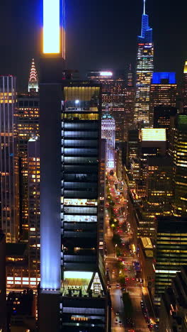 sparkling and glamorous new york at night time. drone flying among tremendous skyscrapers over busy streets. vertical video