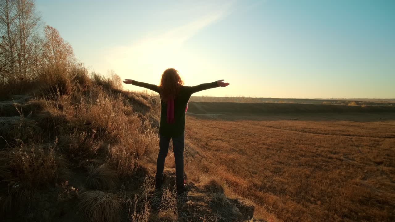 Woman enjoying sunrise in a field