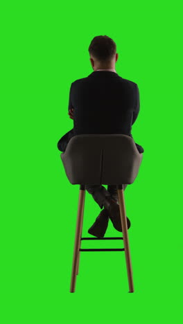 man in suit sitting on a chair